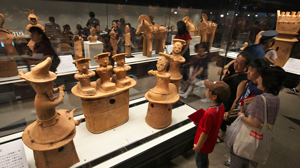 埴輪「三人童女」に見入る親子の写真 埴輪「三人童女」に見入る親子の写真