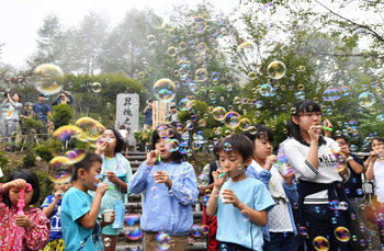 昇魂之碑の前でシャボン玉を飛ばす子どもたちの画像 昇魂之碑の前でシャボン玉を飛ばす子どもたちの画像