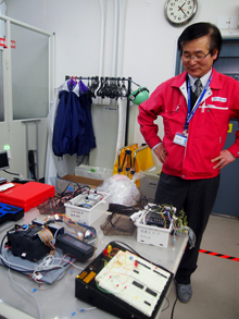 自作の道具を微笑ましく見つめる小棚さんの画像