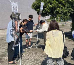 県立女子大学構内でビラを配る様子の写真