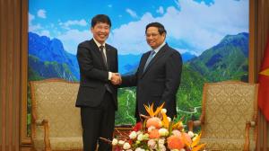 知事とチン首相の握手の写真