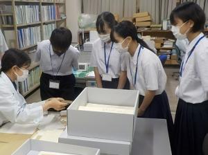 補修作業の様子をのぞき込む生徒たちの写真