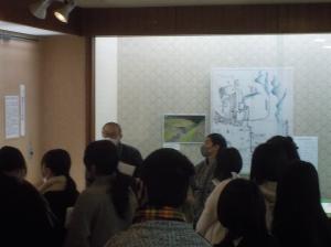 展示室で展示史料の解説を聞く高校生たちの写真