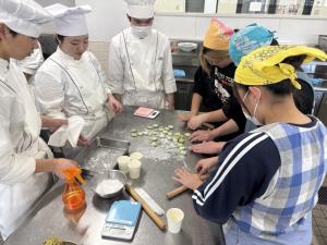 東日本調理師専門学校の学生と一緒に作業している学生の様子の写真