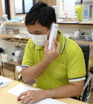 日本語で電話に対応する外国人職員の写真