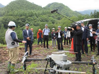 川浦地区（造林地）にてドローンの説明を受けている写真